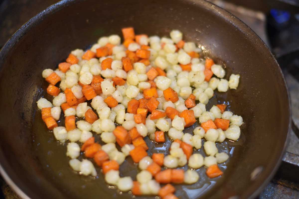 Corn and sweet potatoes are fried in a pan