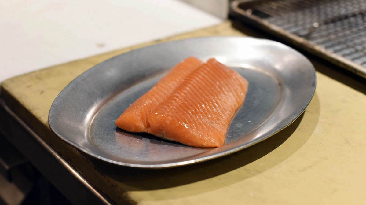 A salmon fillet is prepared for grilling