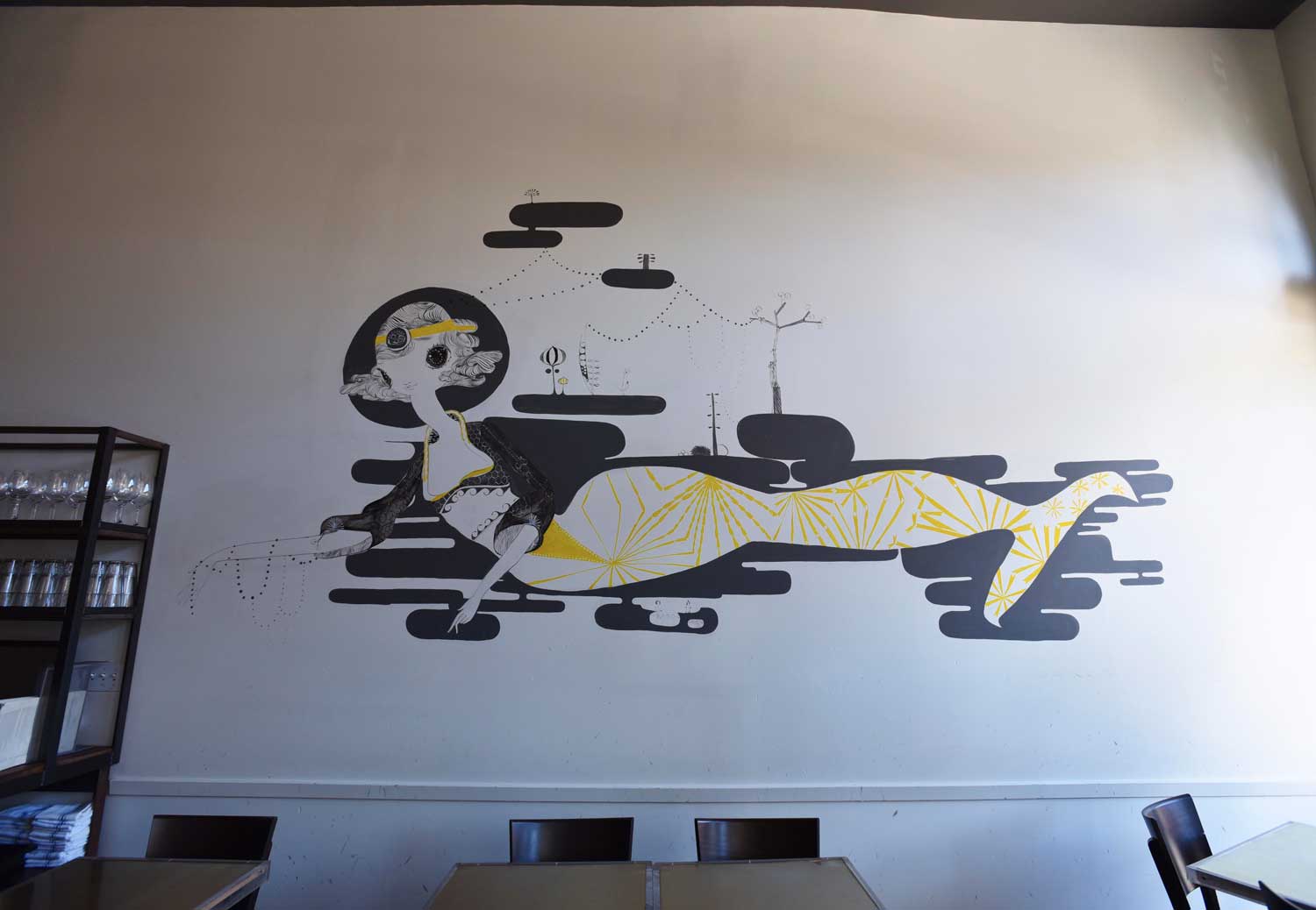 Quirky murals on the wall decorate Bar Crudo's interior.