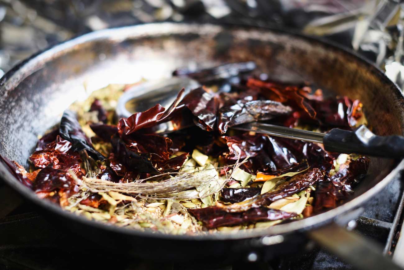 Beautiful chilis and spices are prepped in cast iron skillets