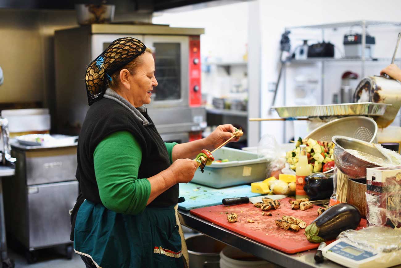 A La Cocina member preps kebabs for a catering job