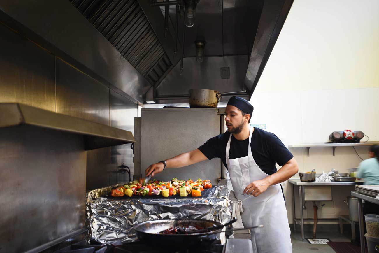 Colorful kebabs are grilled on a foil covered stove