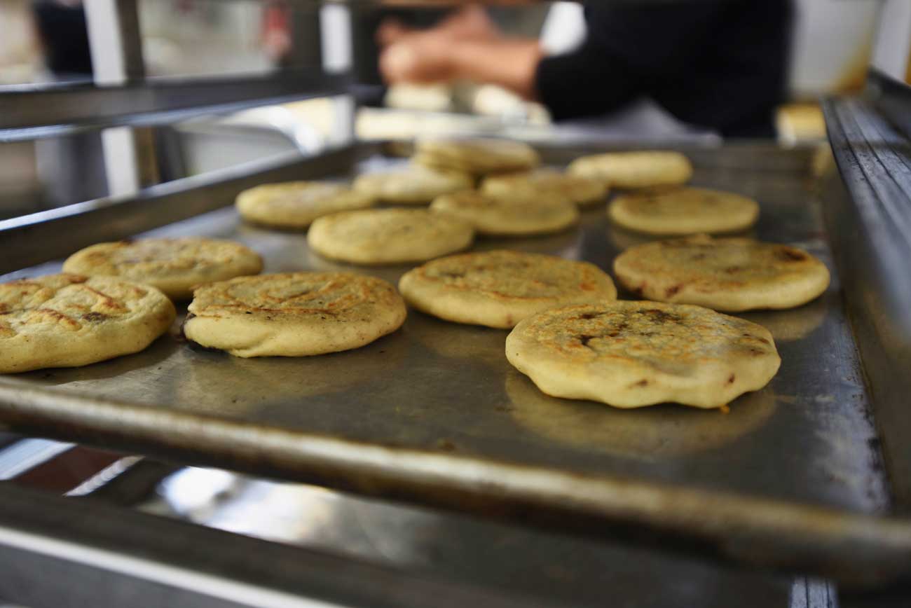 Hot pupusas cool on a rack