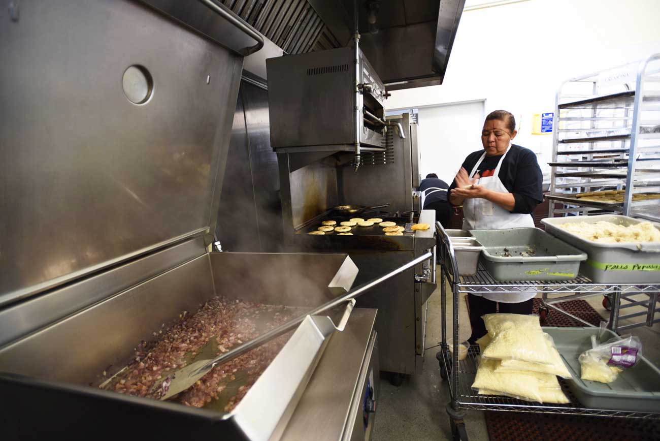 A La Cocina entrepreneur busily prepares pupusas