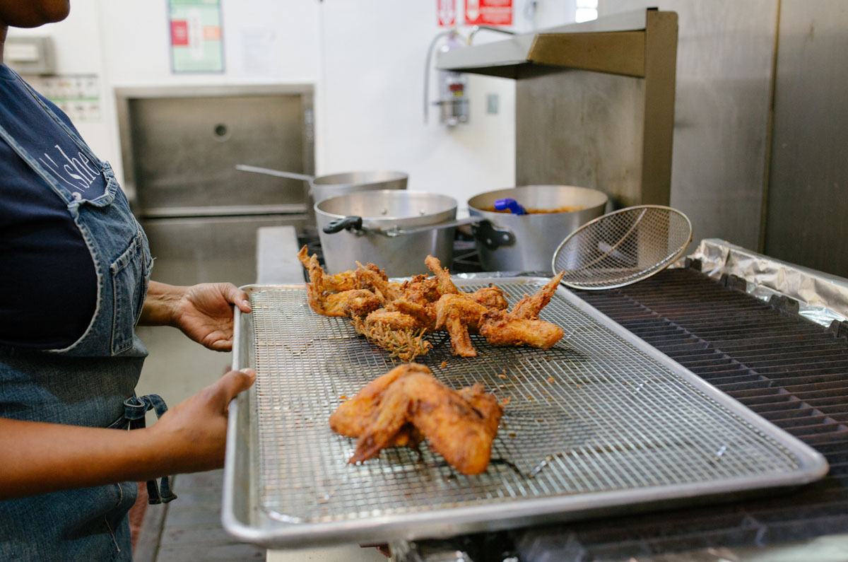 Chef Fernay McPherson holds a tray of freshly fried chicken 
