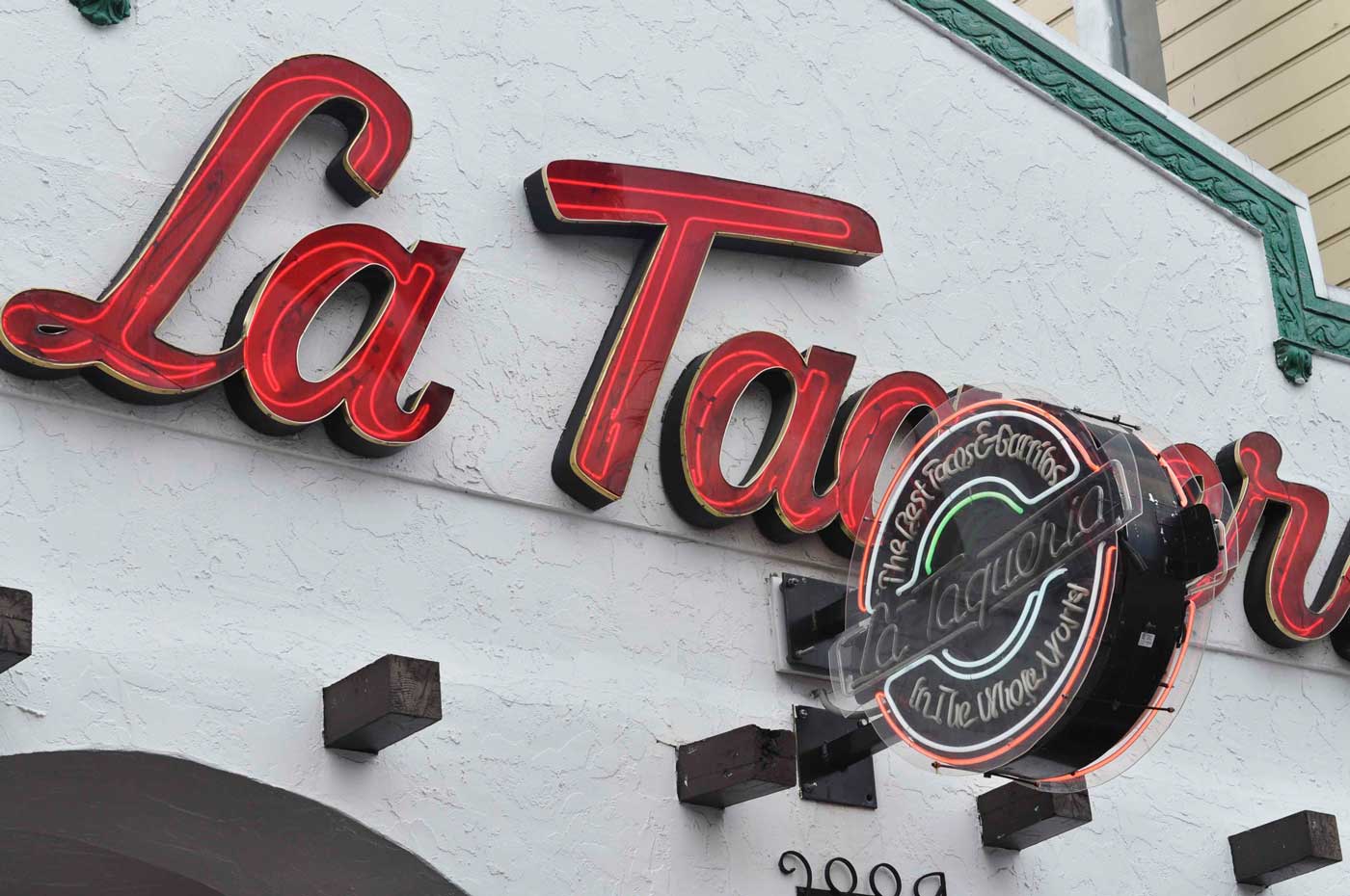 The neon sign welcomes guests into La Taqueria in the Mission