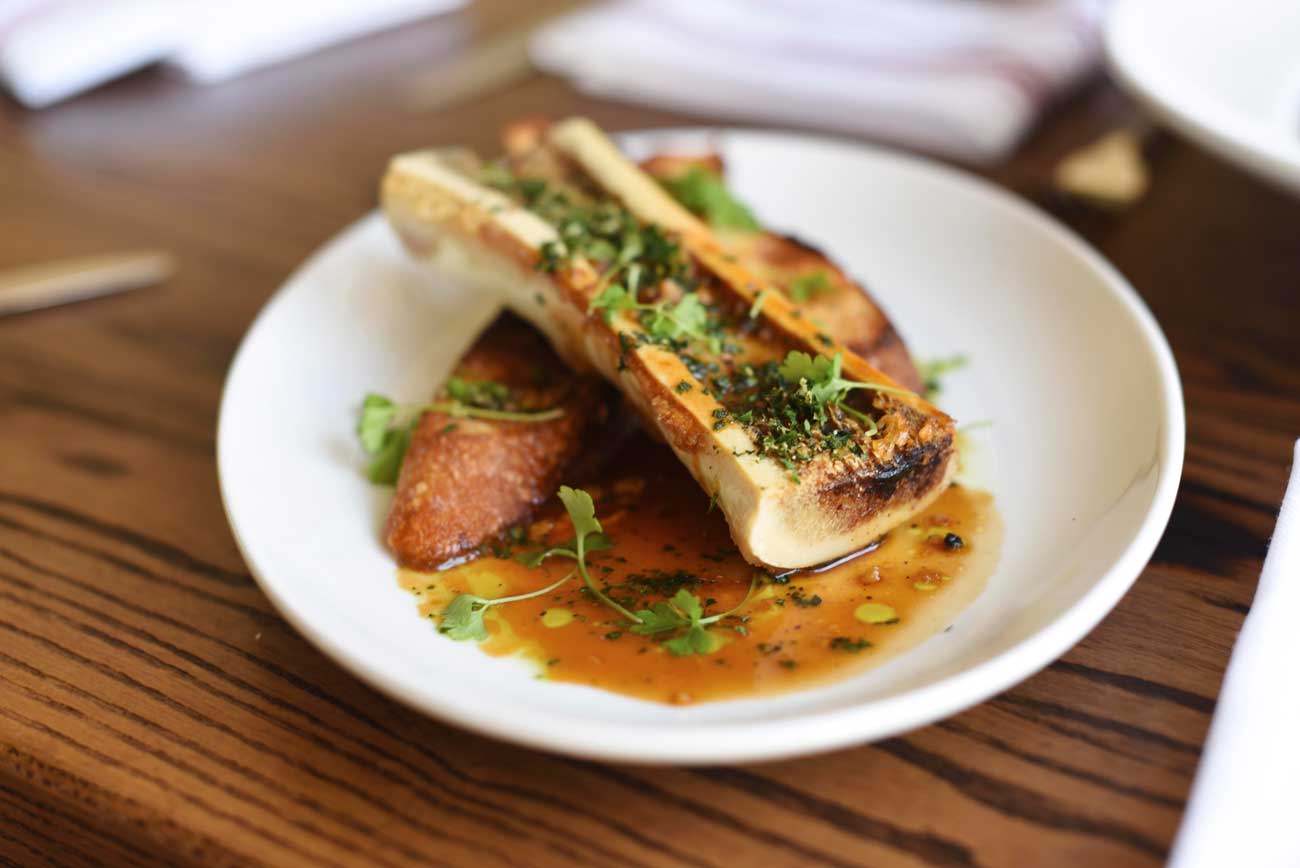 A warm plate of chef Tracey's bone marrow with sherry demi-glace, tarragon-horseradish gremolata, and toasted sourdough ($11) 