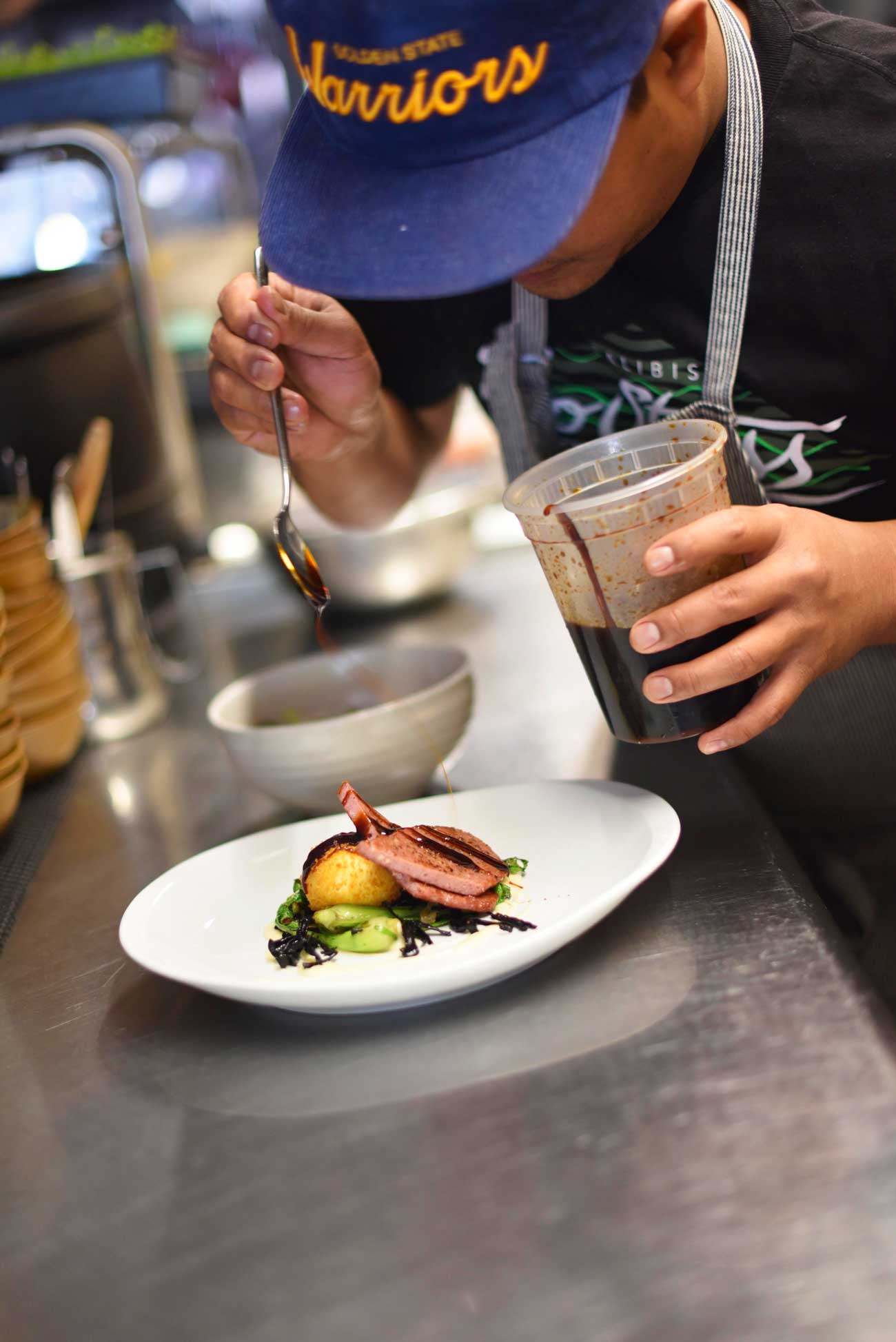 Chef Naputi drizzles a savory sauce over the sous vide spam that's made from scratch at Prbuechu.