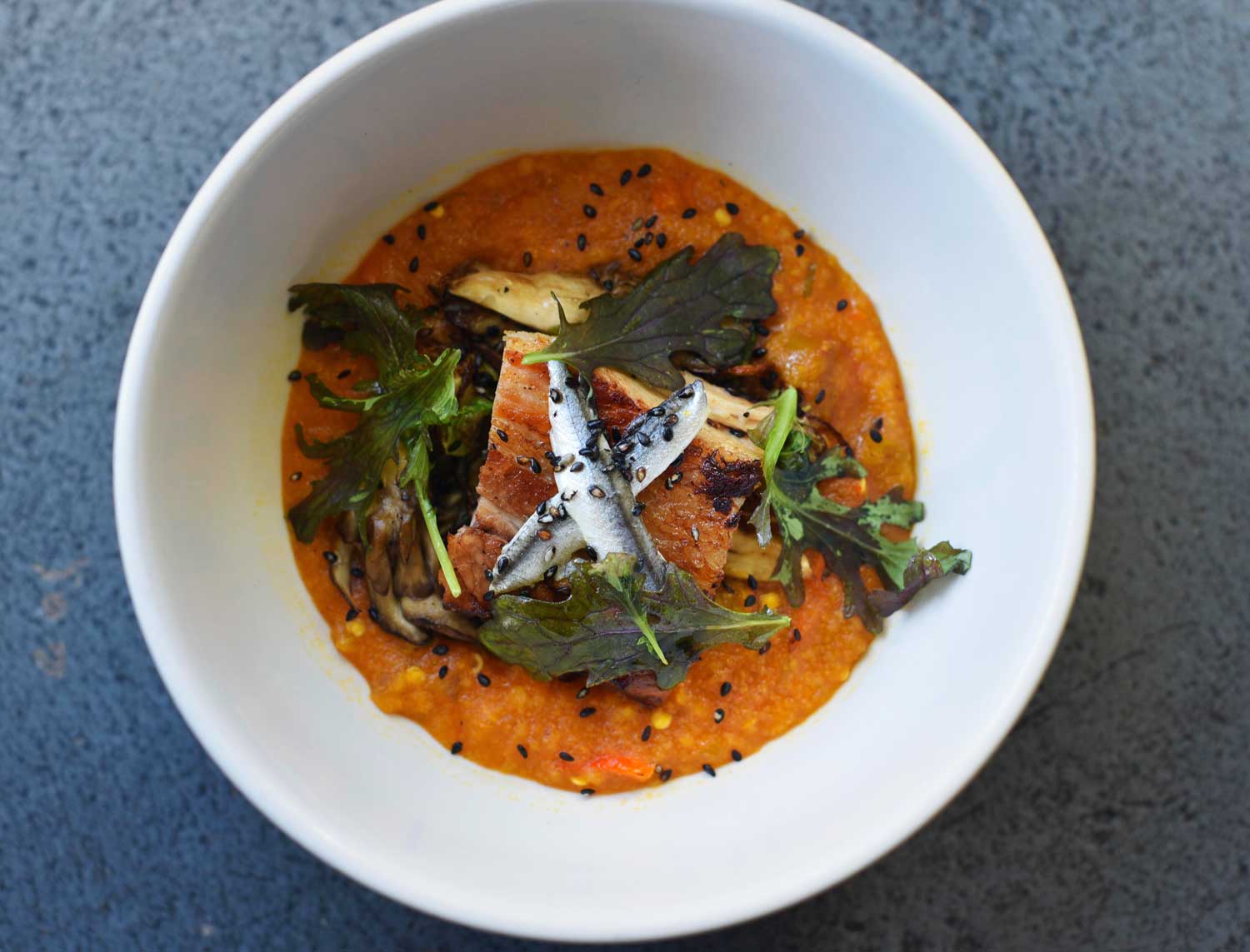 Colorful food is served at Prubechu, like this Chalakiles porridge with achiote, pork belly, and anchovies.