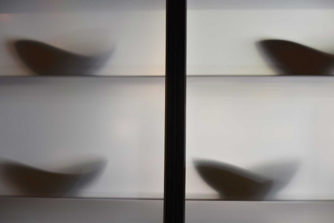Shadows of serving platters are seen through frosted glass separating the kitchen at Volta and the dining area.
