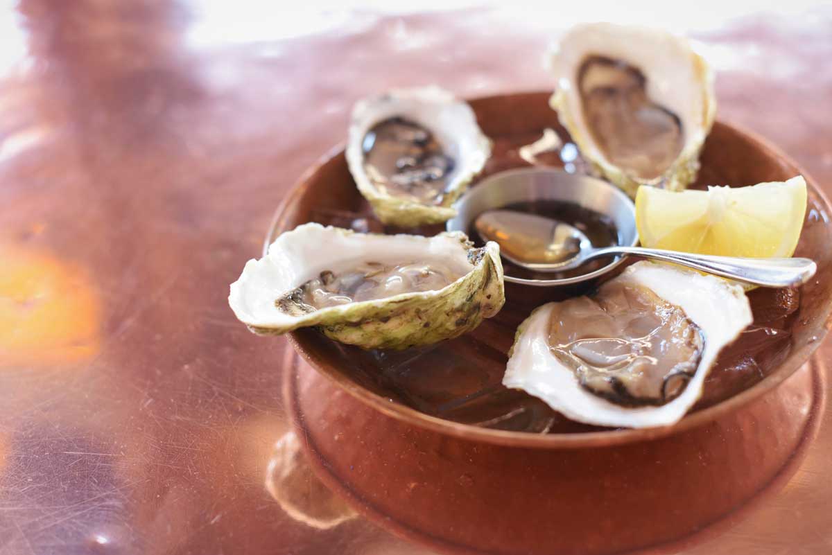 Fresh shucked oysters from Zuni's oyster station, served with a dressing and a lemon wedge, make for a perfect appetizer at this San Francisco haven.