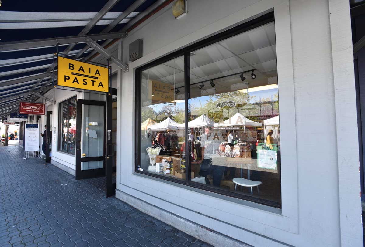A bold yellow sign for Baia Pasta greets Jack London Square visitors.