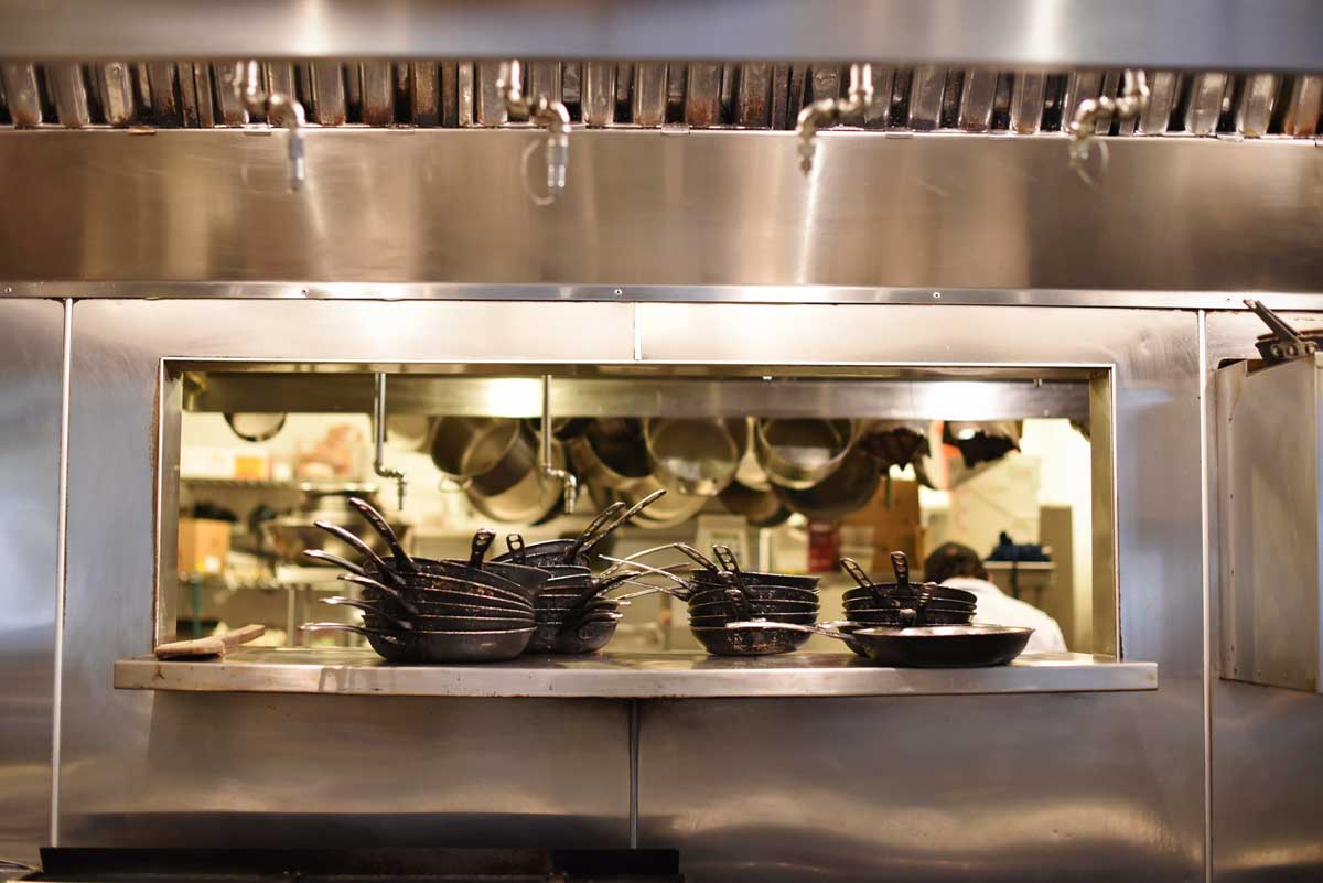 A stainless steel window into the kitchen, where chef Justin Simoneaux prepares plates.