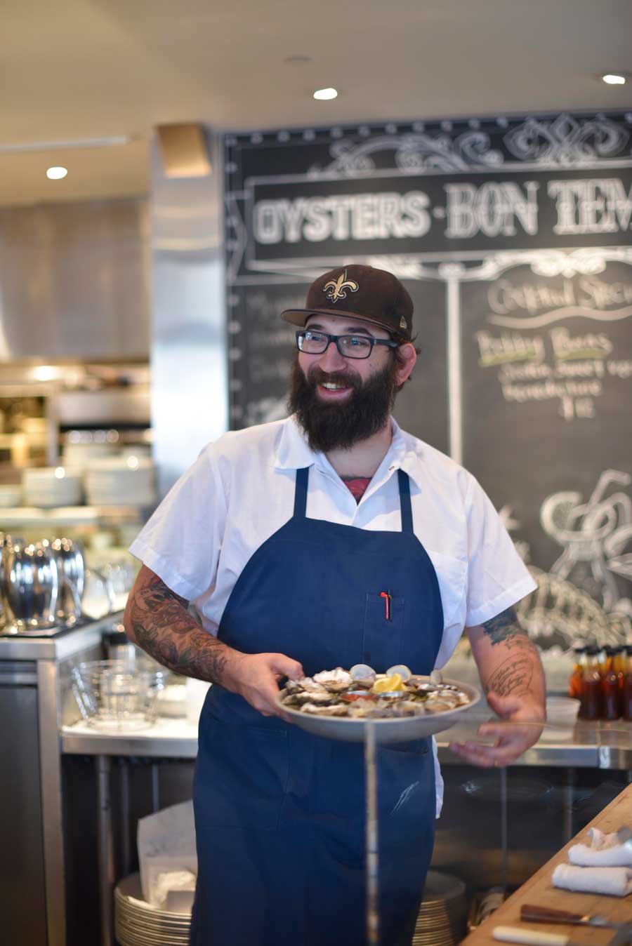 Chef Justin Simoneaux poses with a freshly prepared plate of raw oysters