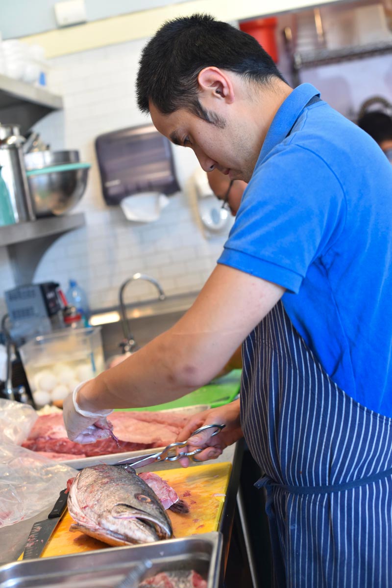 Fresh fish is a specialty at Cassava. Chef and co-owner, Kris Toliao, prepares fish for dinner service.