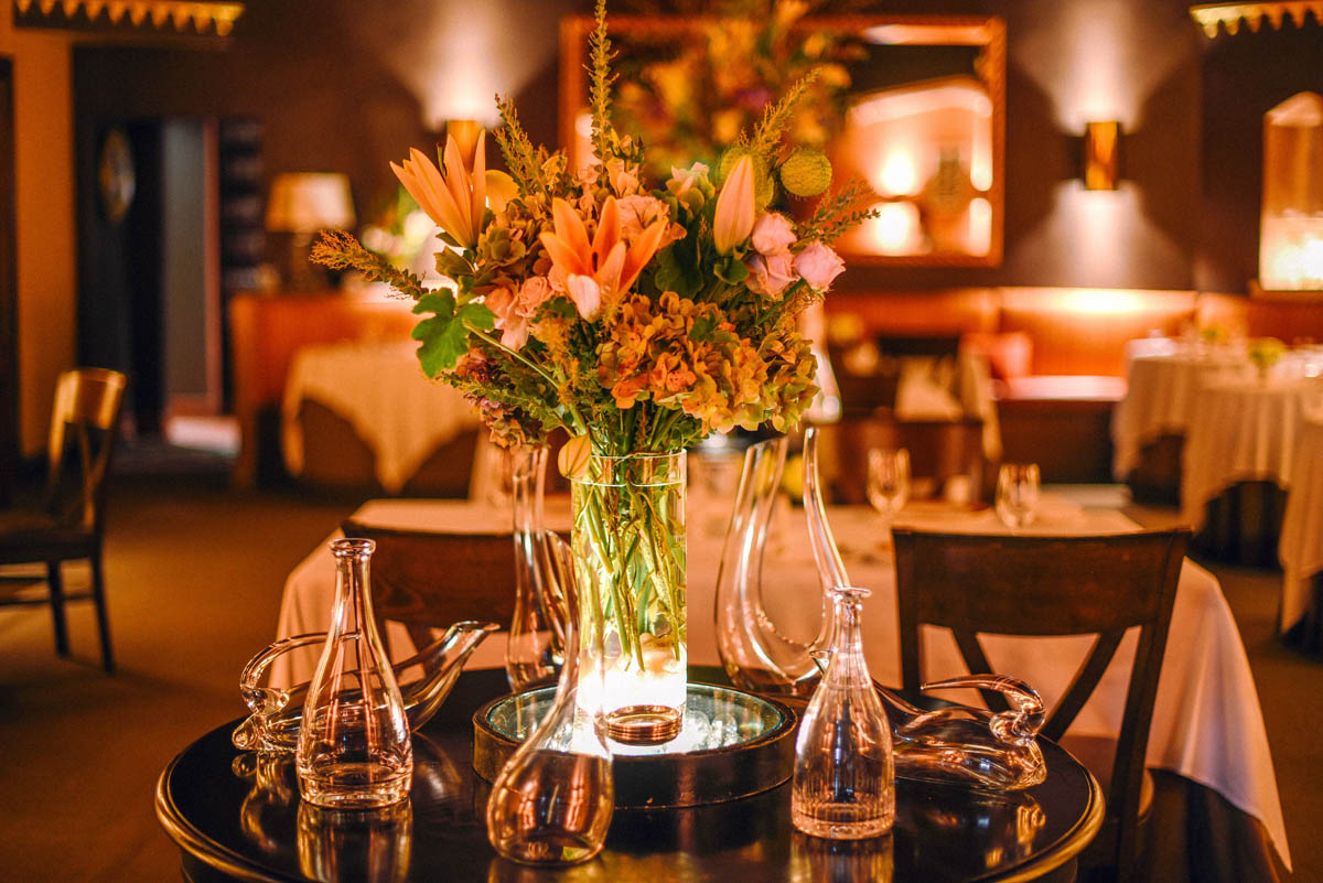 The dimly lit romantic ambiance at Acquerello features flowers and beautiful glassware 