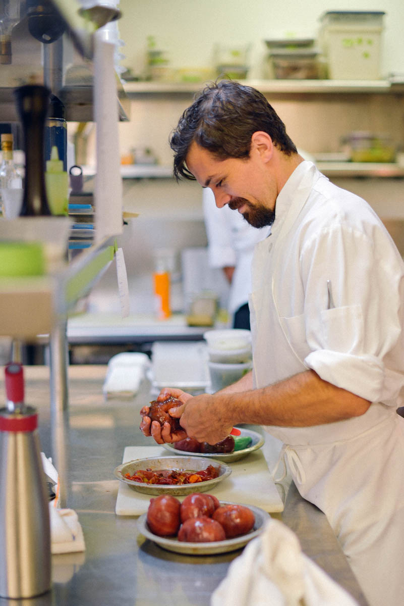 A chef works on heirloom tomatoes for a dish at Acquerello 