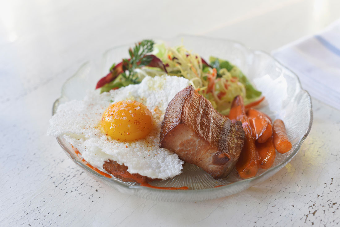 Pork belly and egg, sous vide, served with glazed carrots and a rice flat.
