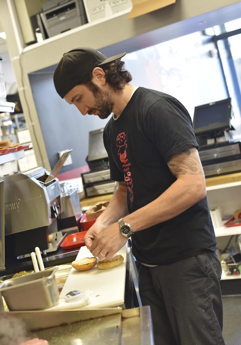 Chef Adam Rosenblum prepares the bun for one of his famous burger creations