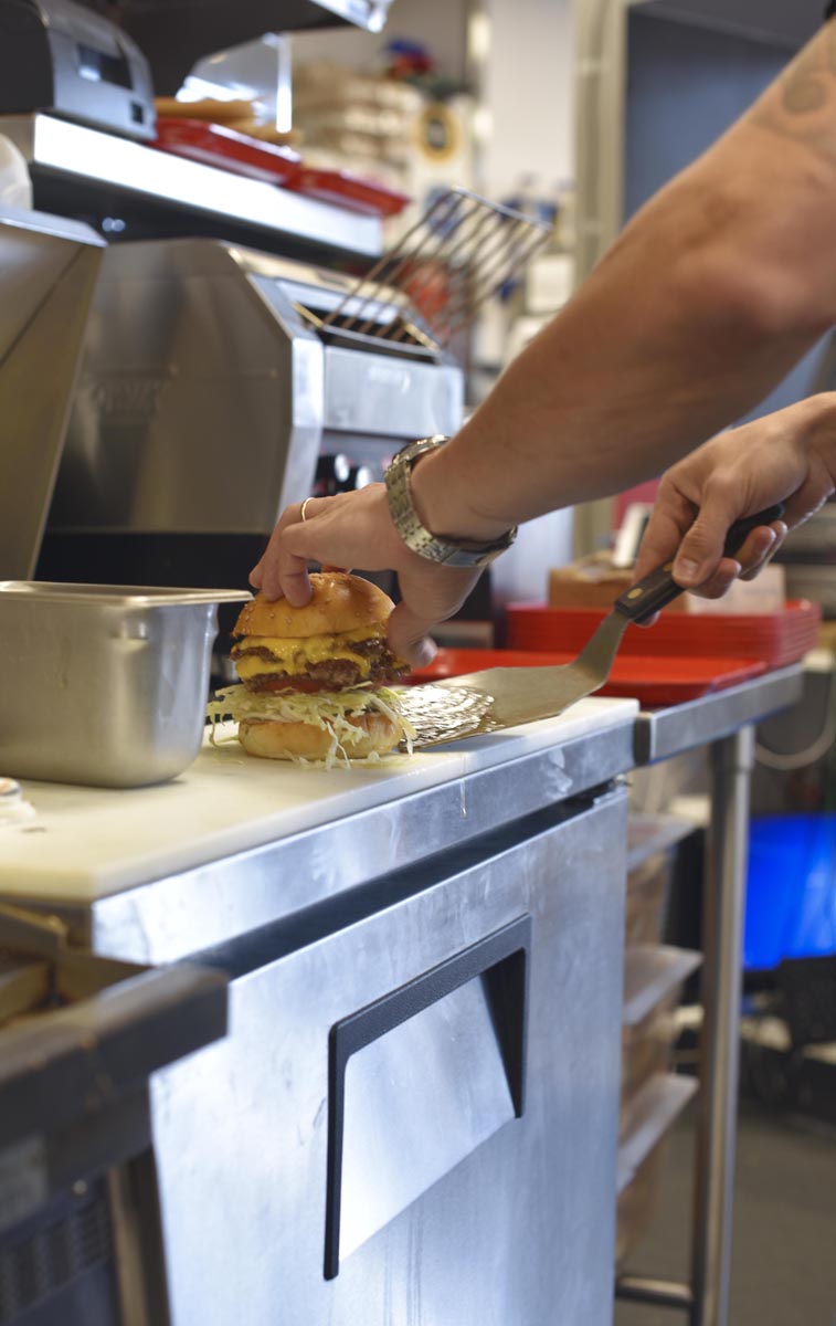A burger gets scooped off the griddle  