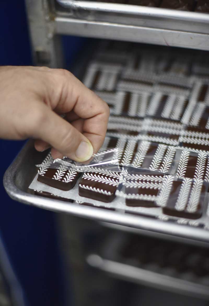 White patterns are painted with sugar onto the tops of the chocolates  