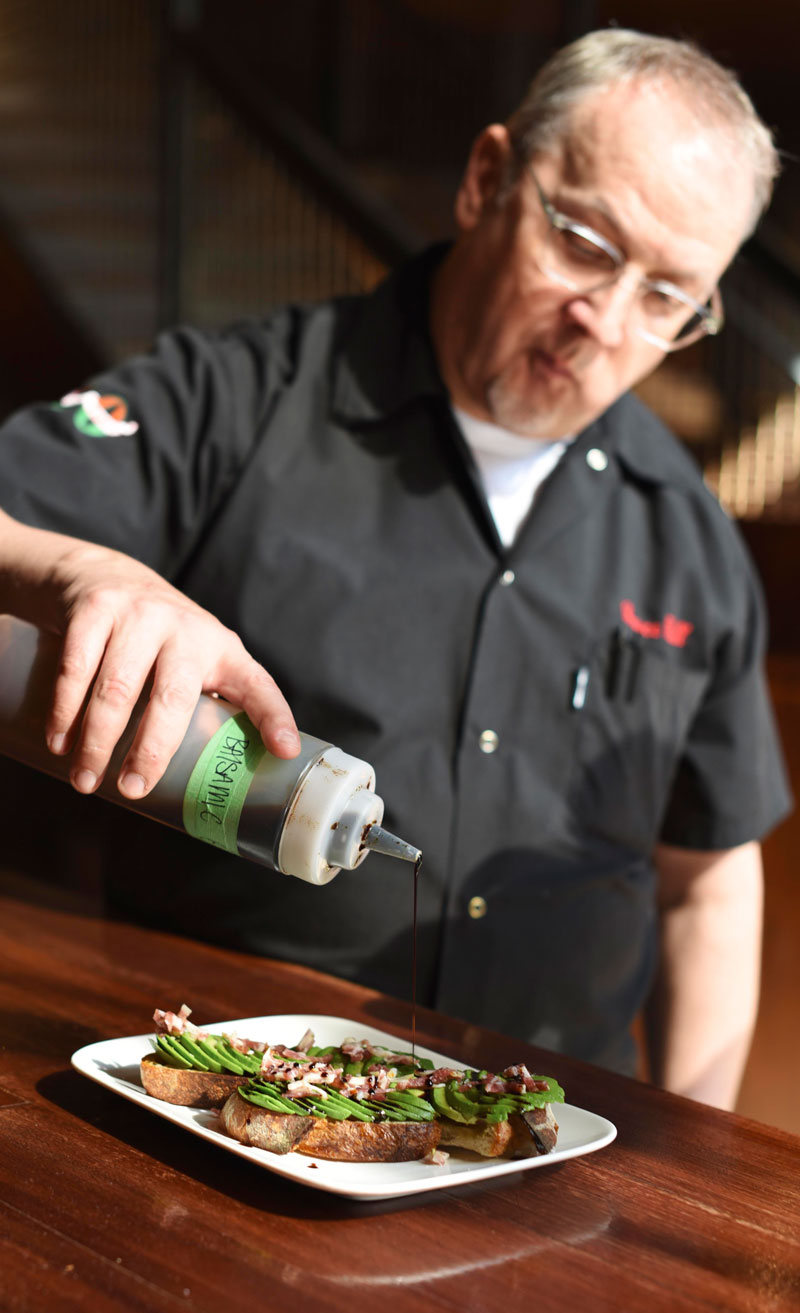 Chef Bruce drizzles the finishing touches on the avocado toast 